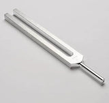 Metal tuning fork on a light gray background